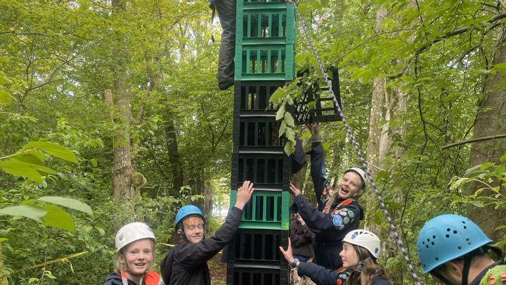 En masse spejder bygger tårn af mælkekasser