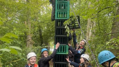 En masse spejder bygger tårn af mælkekasser